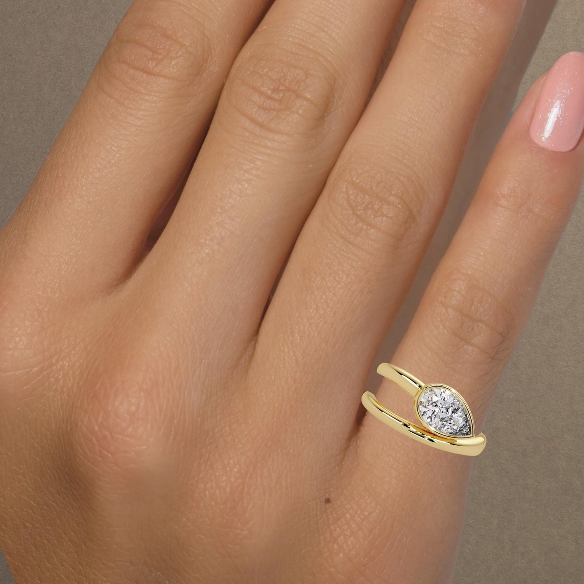Pear diamond bypass ring worn on hand / 14K yellow gold statement ring / east-west bezel-set lab diamond