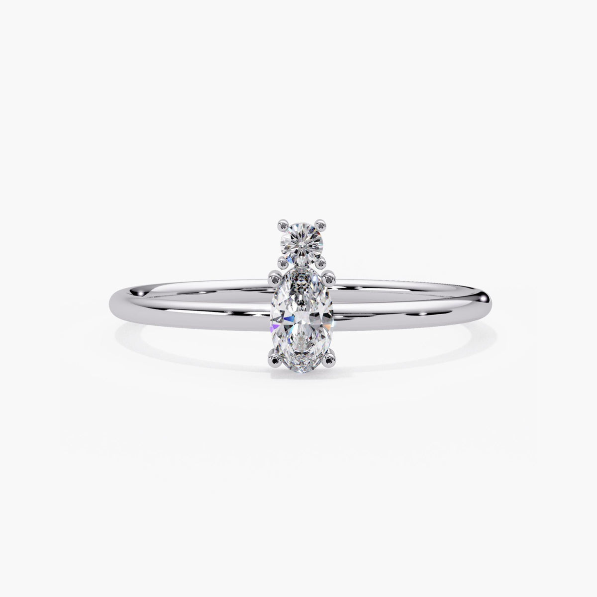 14k white gold two stone diamond ring with an oval and round lab grown diamond on a dainty prong set band.