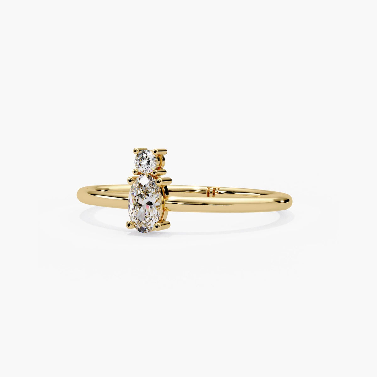 14k yellow gold two stone ring with an oval and round lab grown diamond, each prong set on a slim stacking band.