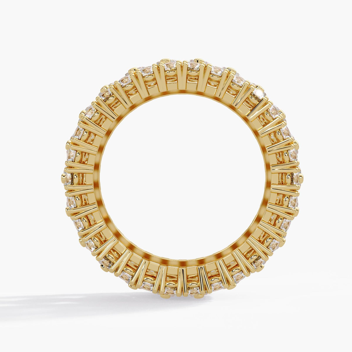 Yellow gold diamond pavé band standing upright, showing its circular interior, polished inner edge and open prong settings extending around the full eternity ring.