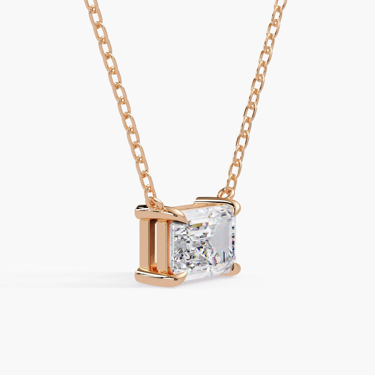 emerald cut diamond pendant / rose gold solitaire necklace / east west diamond setting / step-cut facets / angled view