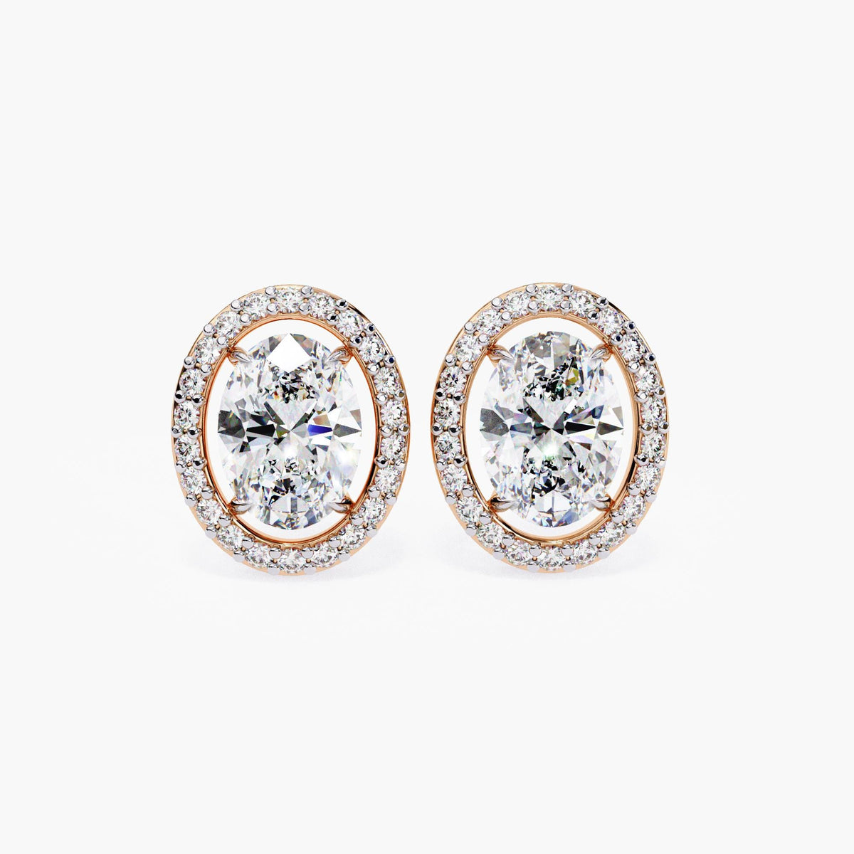 A pair of 14k rose gold oval stud earrings with lab-grown center diamonds, each framed by a floating halo of round diamonds.