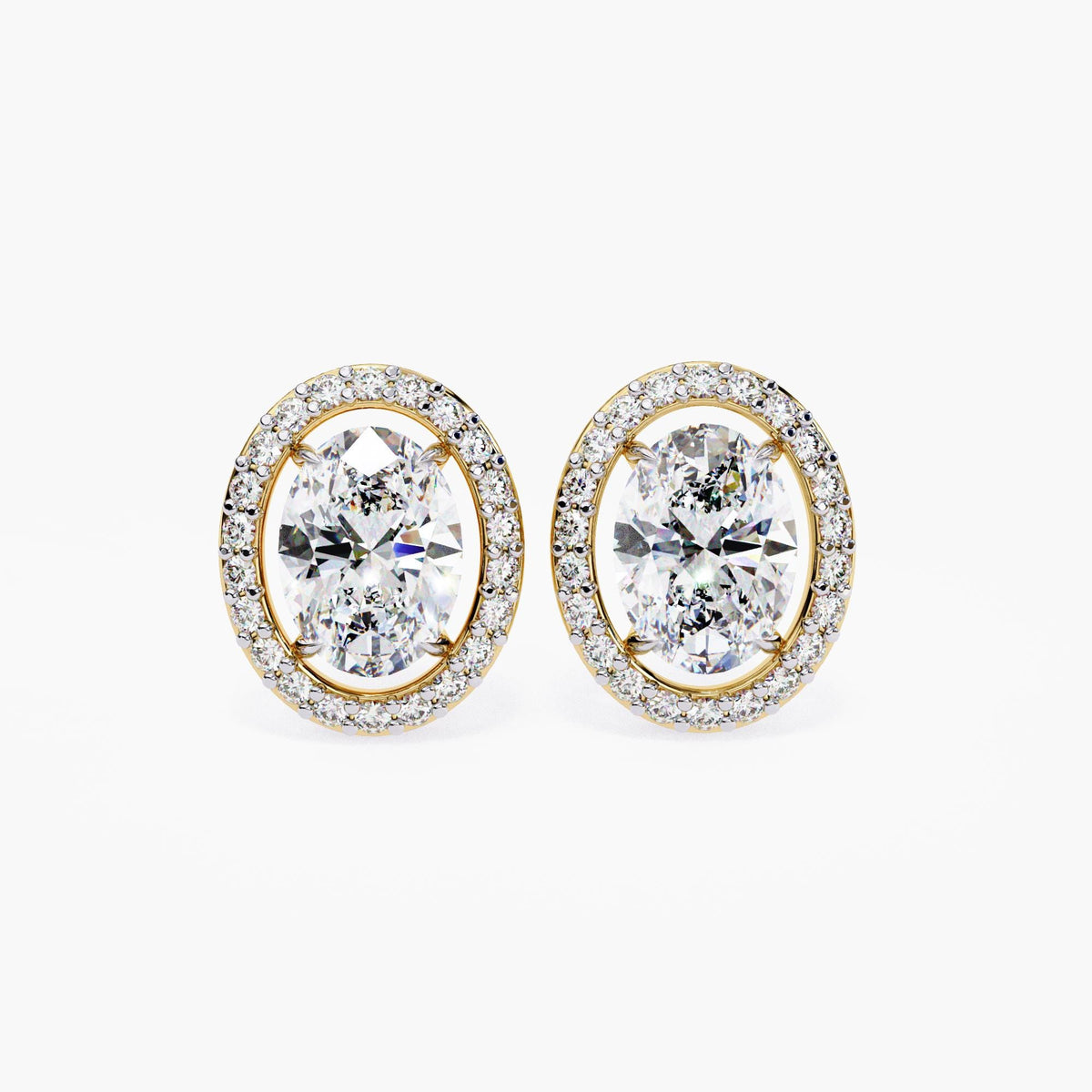 A pair of 14k yellow gold oval stud earrings with oval lab-grown center diamonds framed by a floating halo of smaller round diamonds.