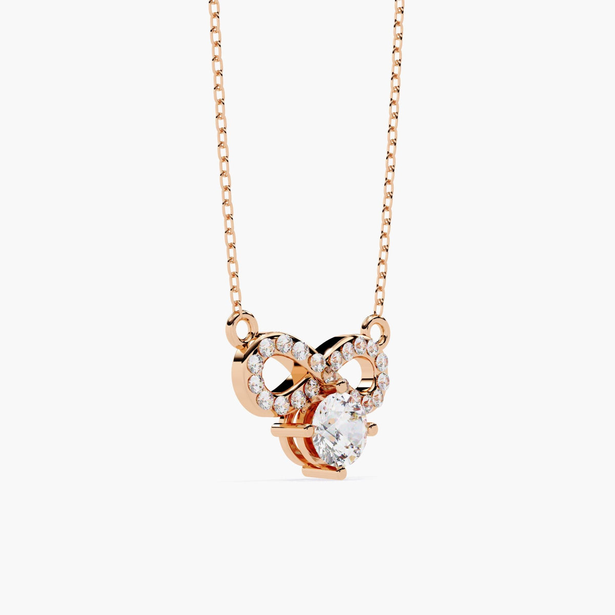 A rose gold infinity necklace with a diamond solitaire stone under the infinity symbol.