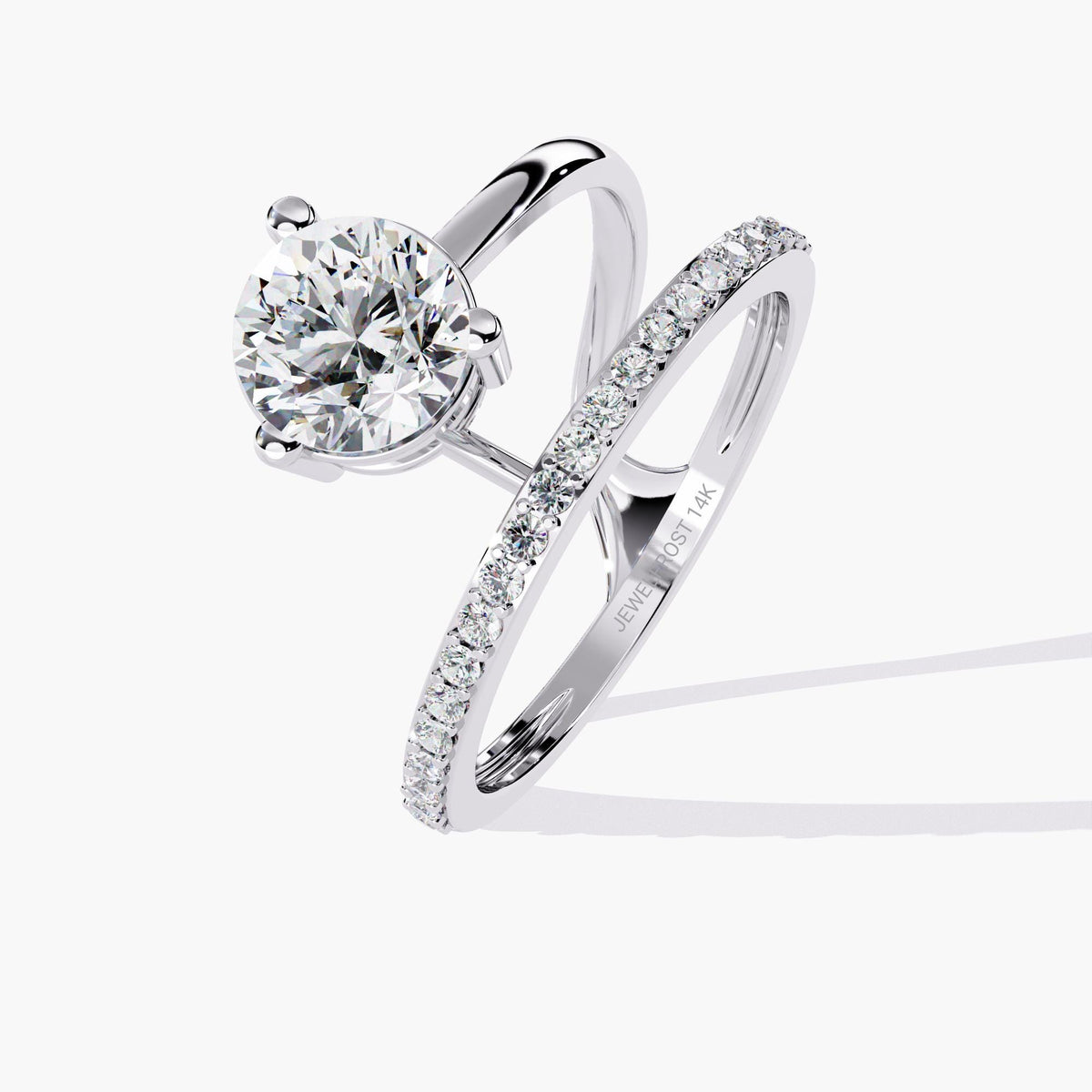 A white gold engagement ring with a round brilliant cut diamond center stone and a pave diamond band. The band is split and wraps around the center stone.