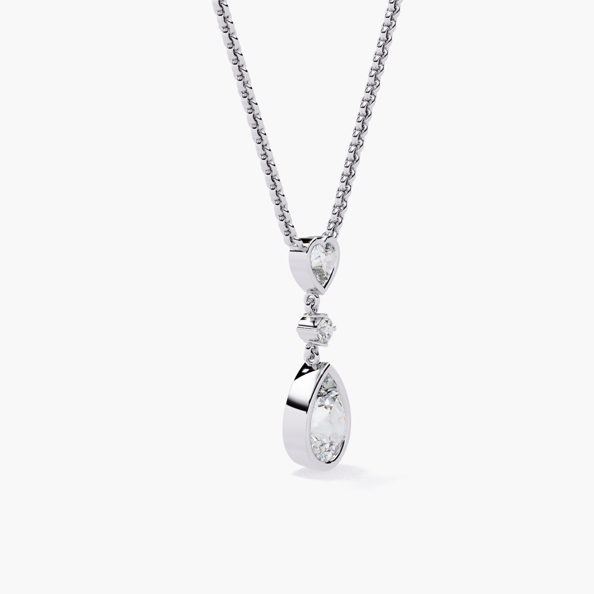 A white gold chain necklace with a pear-shaped diamond pendant and a heart-shaped diamond accent.