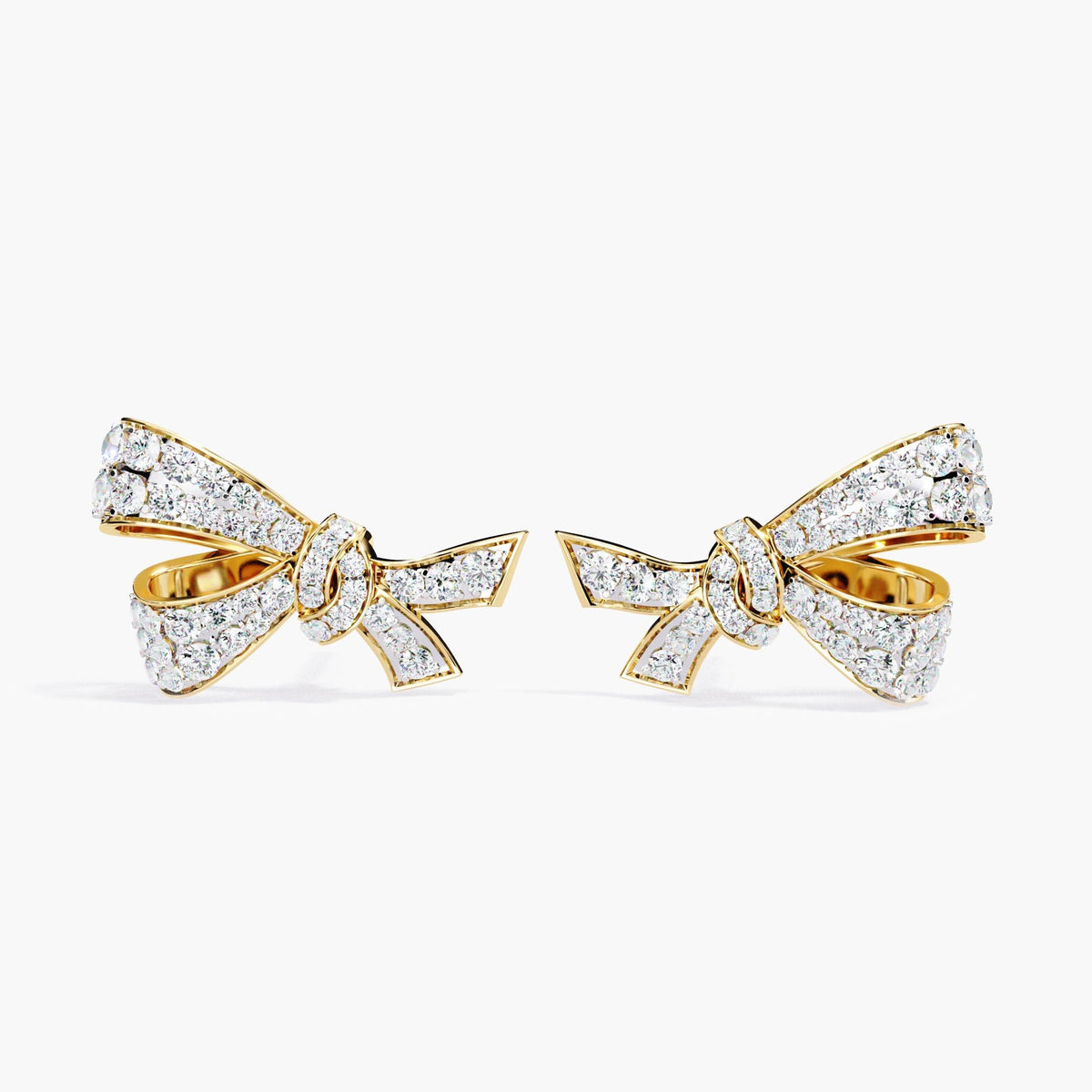 A pair of gold earrings with a small bow design made of clear diamonds.