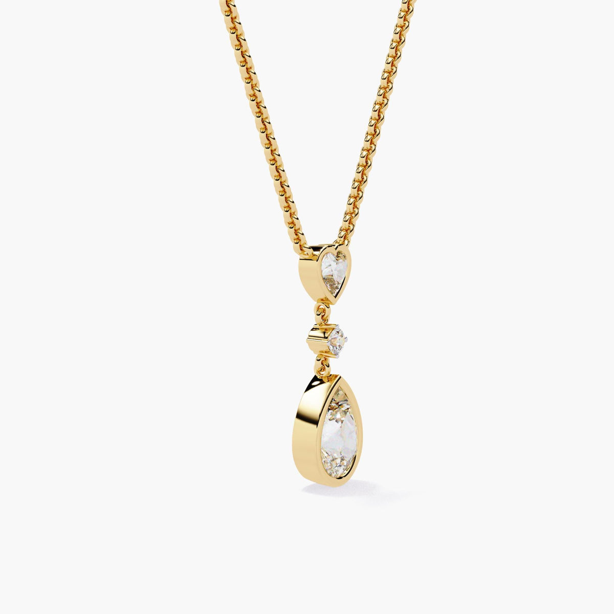 A gold chain necklace with a pear-shaped diamond pendant and a heart-shaped diamond accent.