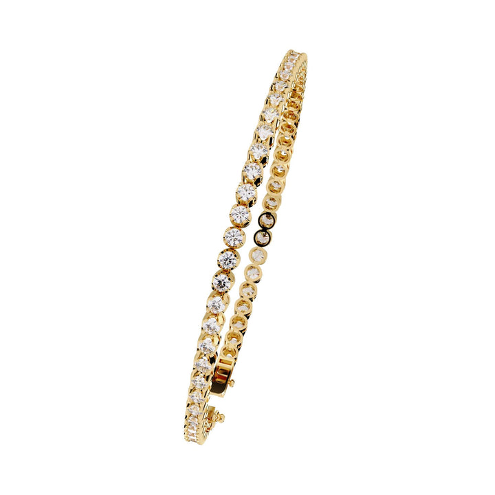 A gold bracelet with a row of small clear diamonds.