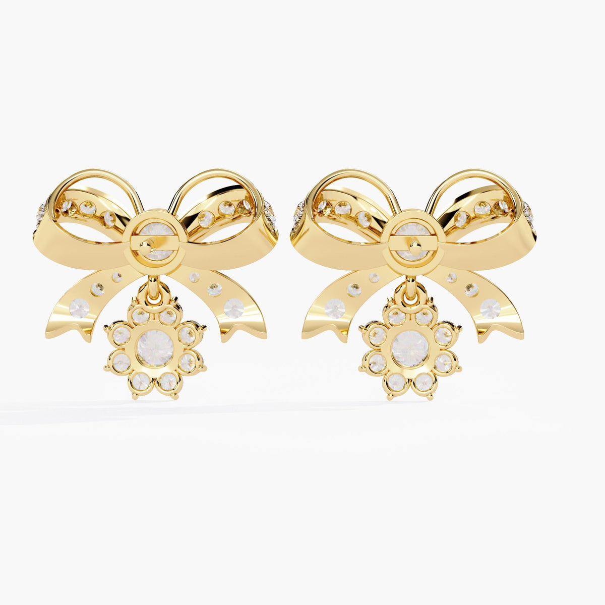 A pair of gold bow earrings with dangling clear round diamonds. The bows are made of small clear stones with gold accents.