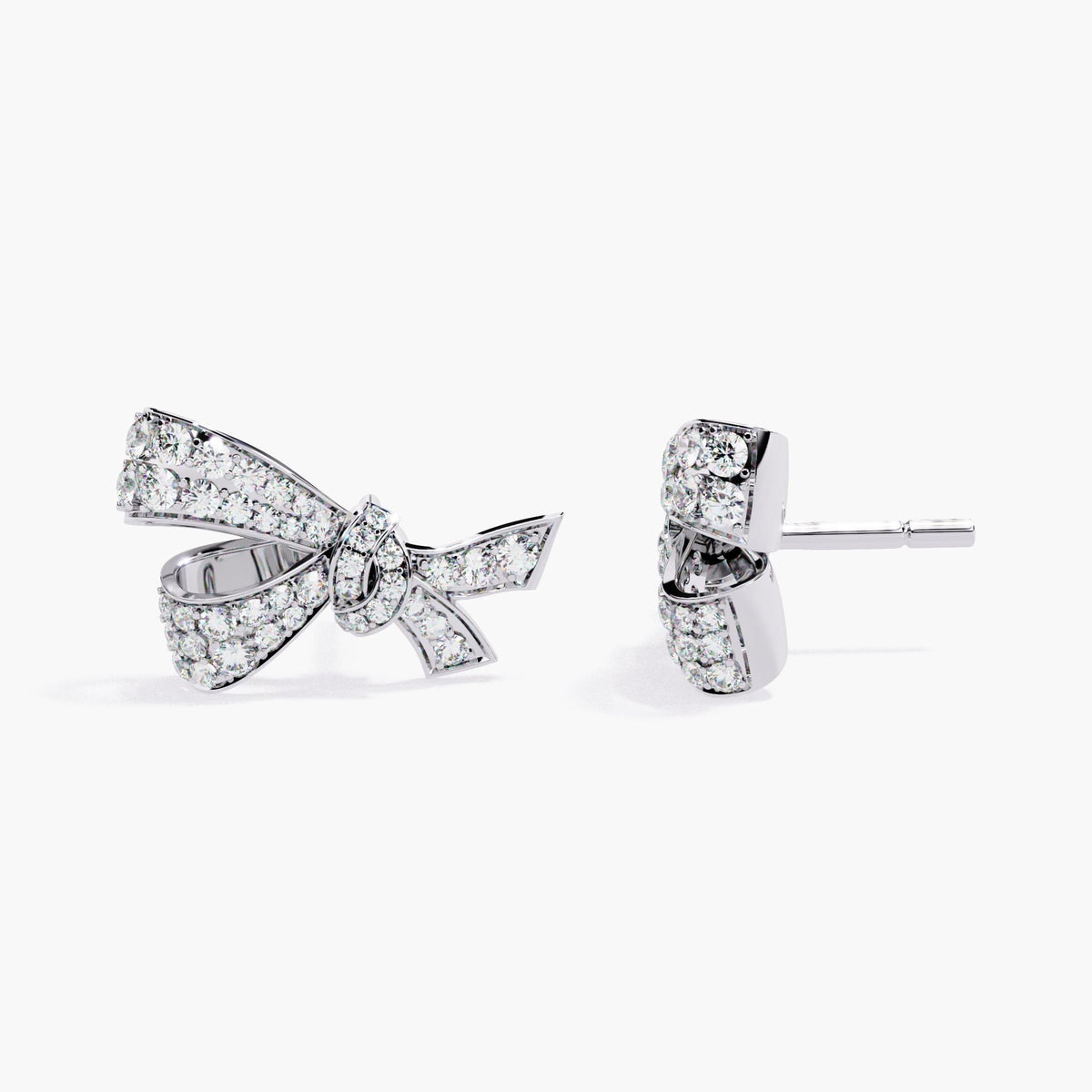 A pair of white gold earrings with a small bow design made of clear diamonds.
