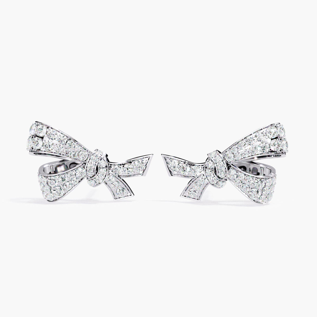 A pair of white gold earrings with a small bow design made of clear diamonds.