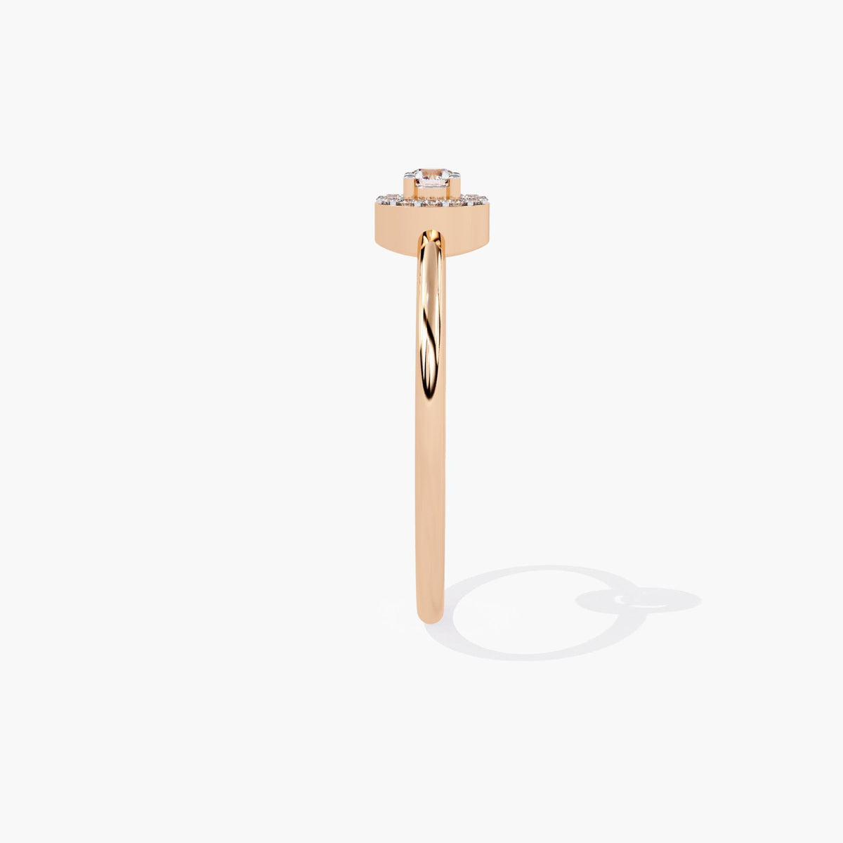 A rose gold band ring with a single round diamond set in a halo of smaller diamonds.