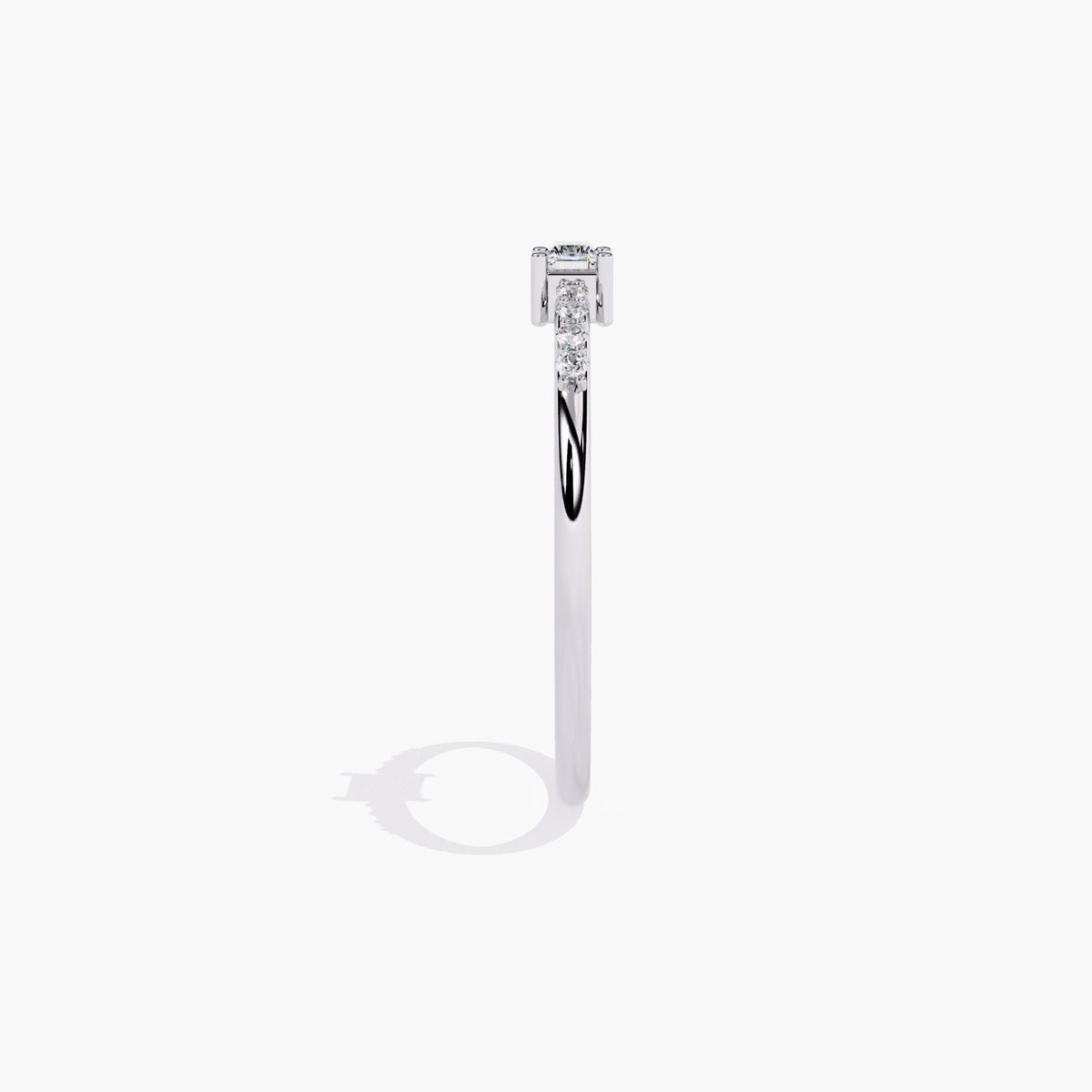 A thin white gold band with a small rectangular diamond in the center and smaller round diamonds on either side of the center stone.