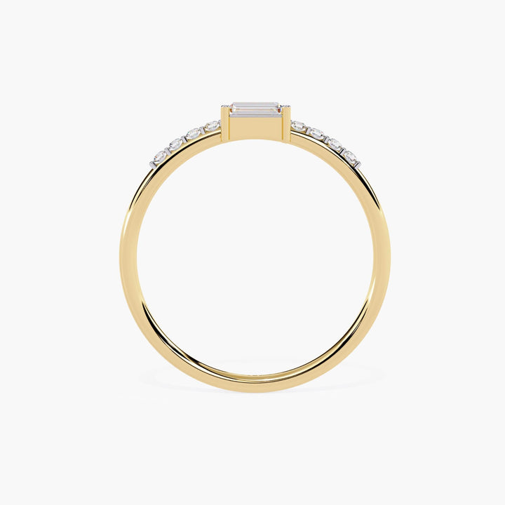 A thin yellow gold band with a small rectangular diamond in the center and smaller round diamonds on either side of the center stone.