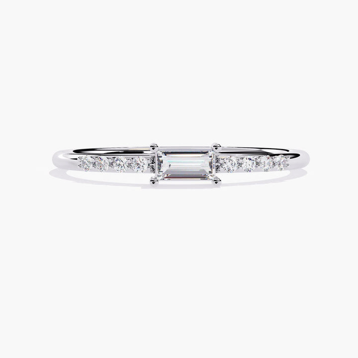 A thin white gold band with a small rectangular diamond in the center and smaller round diamonds on either side of the center stone.