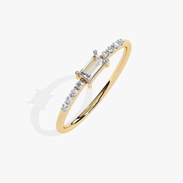 A thin yellow gold band with a small rectangular diamond in the center and smaller round diamonds on either side of the center stone.