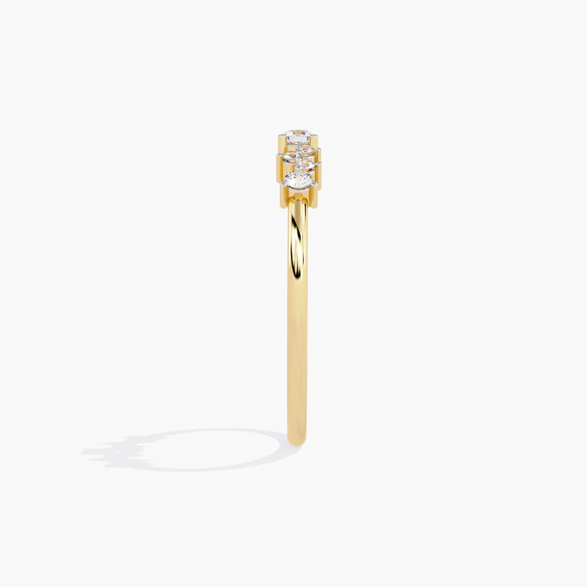 A yellow gold band ring with a cluster of small diamonds and a larger round diamond in the center.