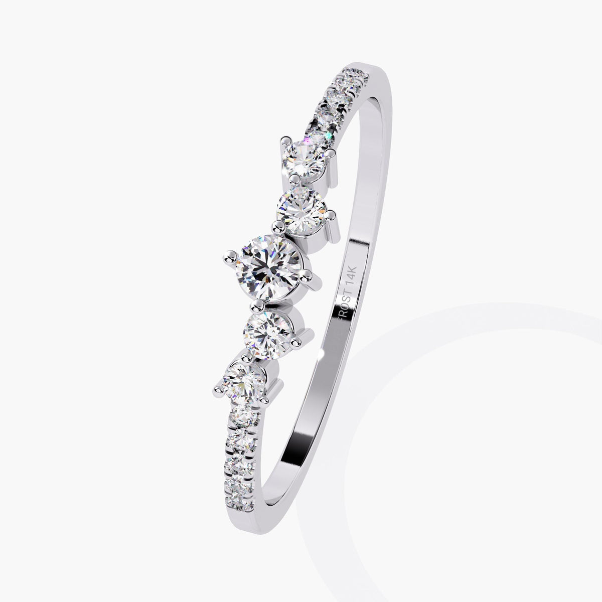 Angled view of a dainty 14k white gold ring with a curved cluster of round natural diamonds and pavé accents. A romantic stacking ring or wedding band for her.
