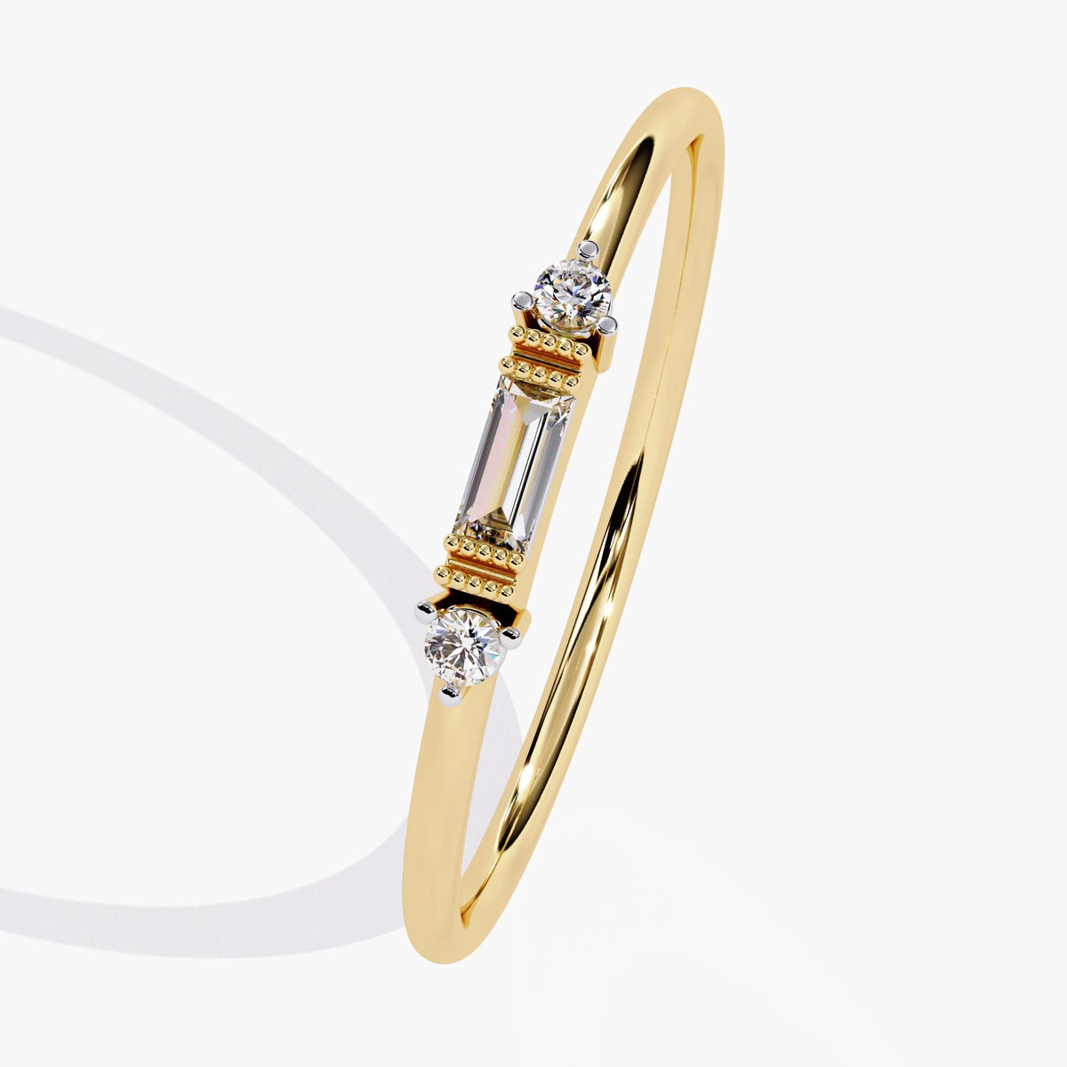 Angled view of a 14K yellow gold ring with a baguette diamond at the center and two round diamonds on either side. Makes a delicate gift for her birthday or graduation.