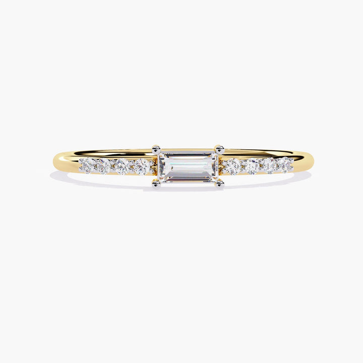 A thin yellow gold band with a small rectangular diamond in the center and smaller round diamonds on either side of the center stone.