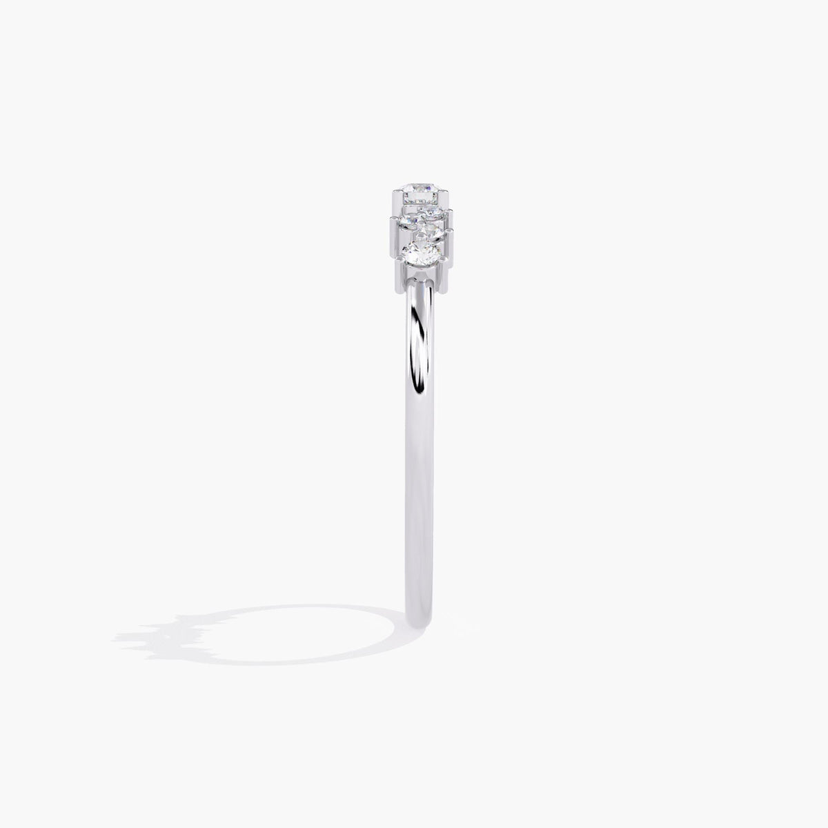A white gold band ring with a cluster of small diamonds and a larger round diamond in the center.