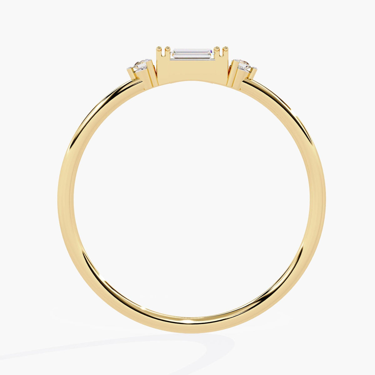 A yellow gold ring with three small diamonds. The center diamond is a baguette cut and the two diamonds on either side are round.