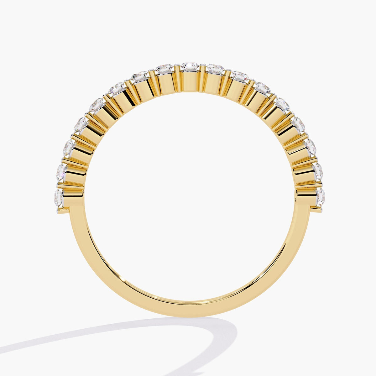 Side profile view of a half eternity floating diamond ring in 14k yellow gold, showcasing the open single prong setting that elevates each round lab-grown diamond for maximum brilliance and a clean, airy silhouette.
