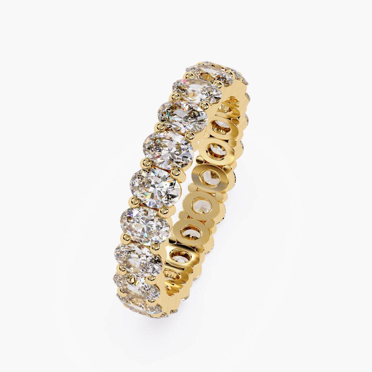 A gold band ring with a row of oval shaped diamonds set in a pave setting.