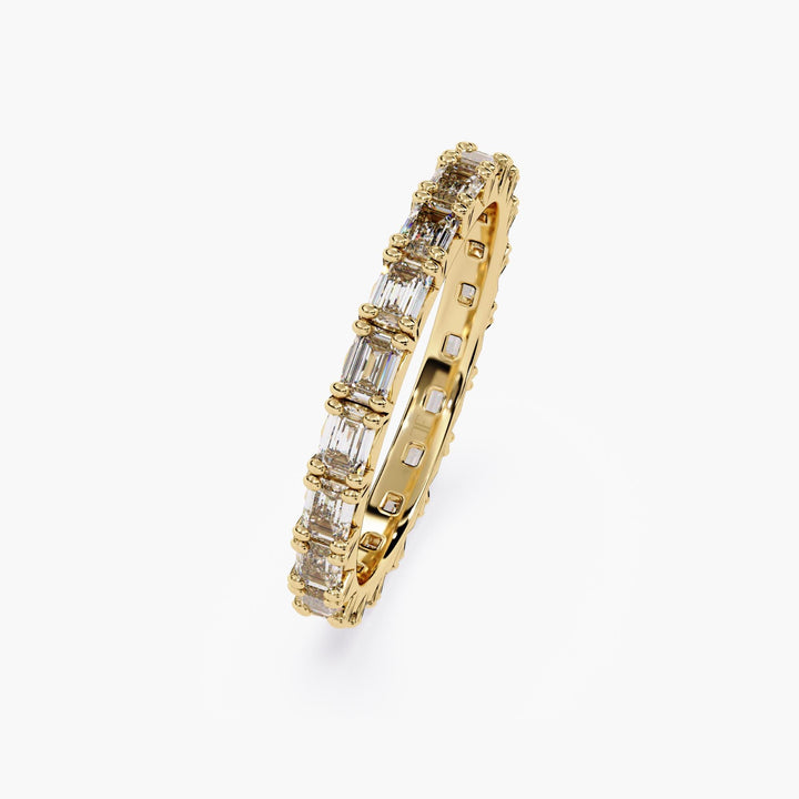A gold band with a row of emerald cut diamonds.