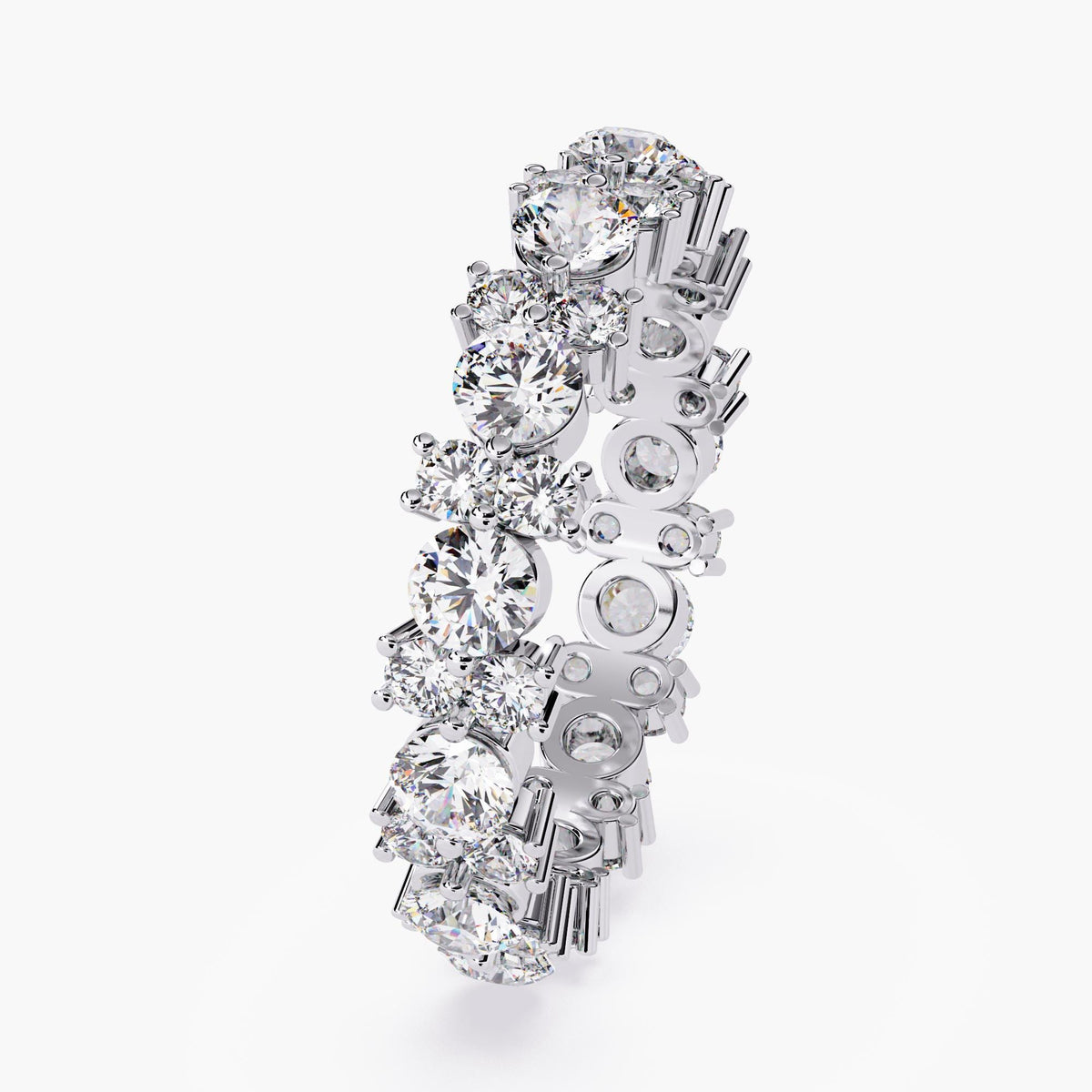 A white gold full eternity ring with round cut diamonds in different sizes.