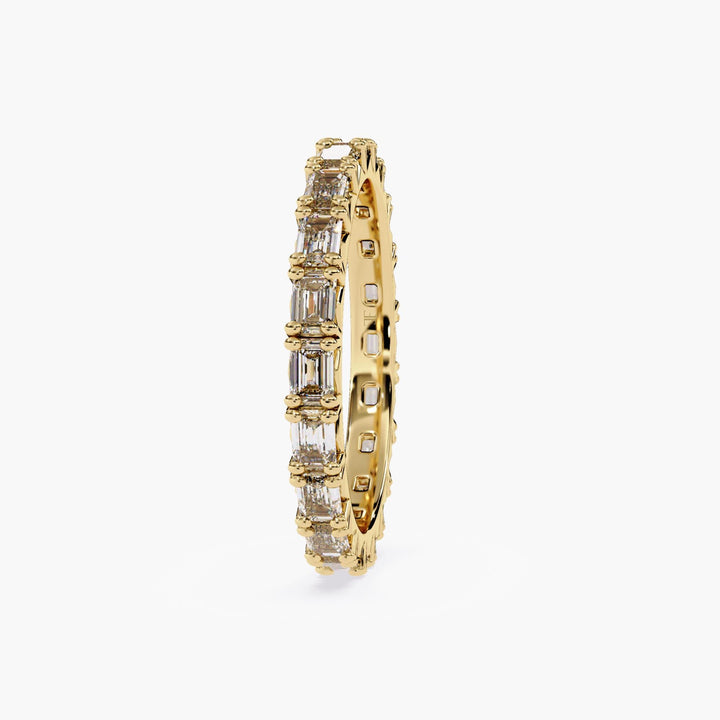 A gold band with a row of emerald cut diamonds.