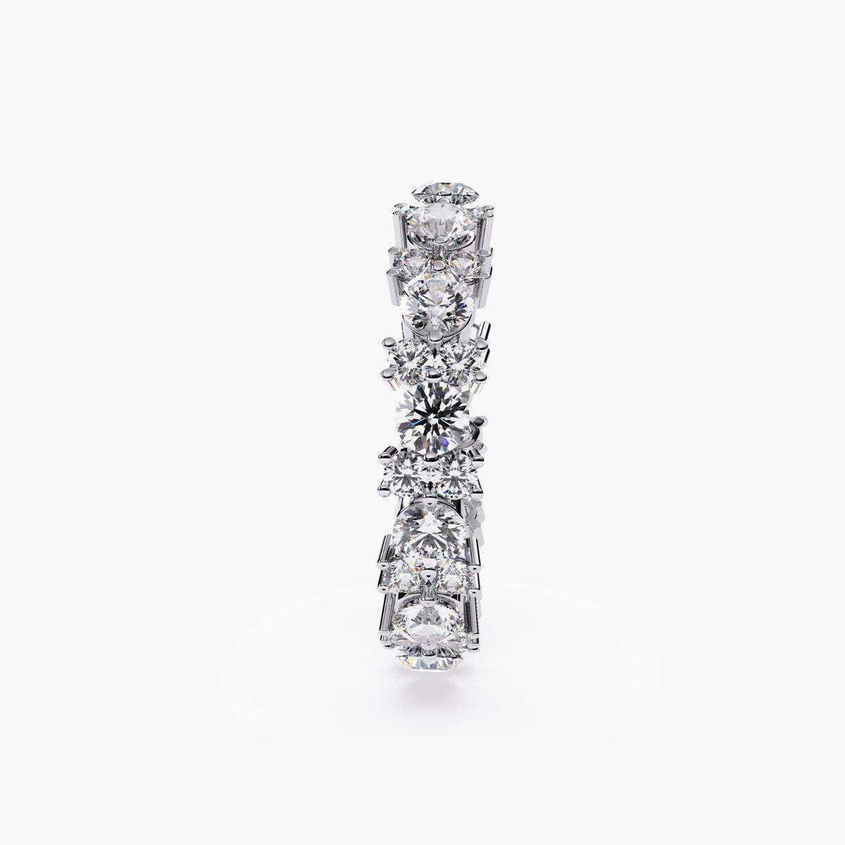 A white gold full eternity ring with round cut diamonds in different sizes.
