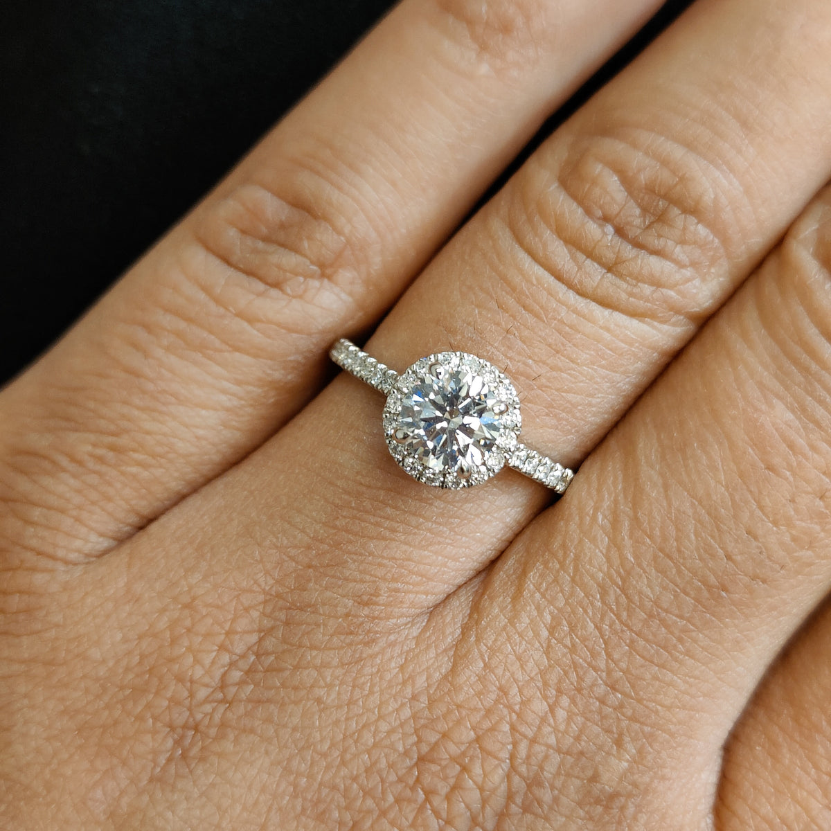 Round lab-grown diamond halo engagement ring in white gold, shown on hand. Features a pavé band and IGI-certified center stone. Elegant, timeless design for proposal, anniversary, or bridal jewelry.