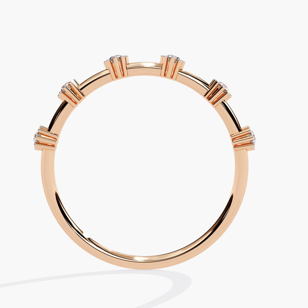 Back view of a 14k rose gold diamond band showing the elevated prong settings from behind. The six round natural diamonds are evenly spaced along the slim polished band, highlighting the open space and structural craftsmanship of the floating design.