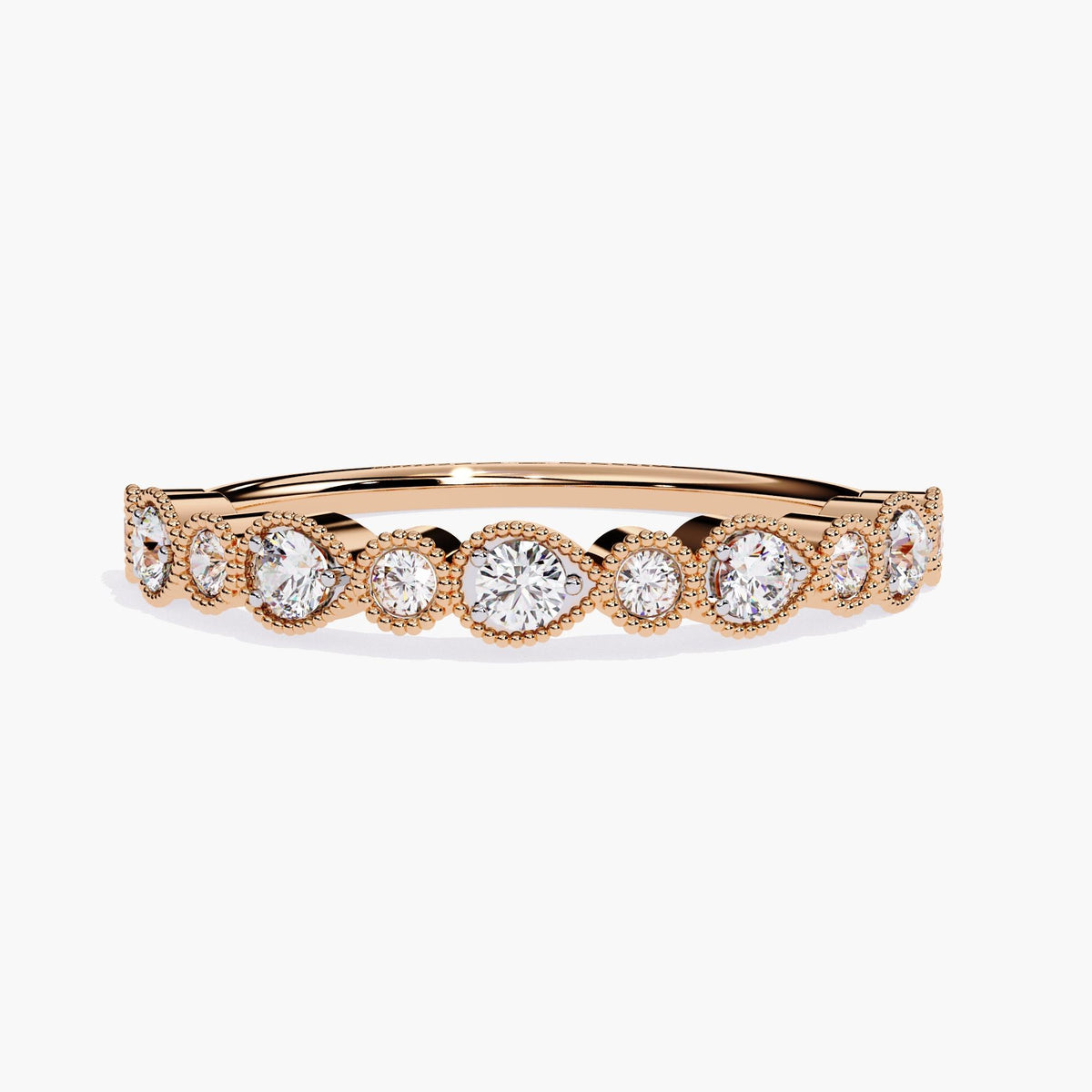 "A rose gold stackable eternity band featuring alternating bezel-set round and pear-shaped diamonds. The diamonds, set in delicate milgrain detailing, create a continuous pattern that exudes timeless beauty and sophistication. Perfect for stacking with other rings or wearing on its own, this band adds a refined, vintage-inspired touch.