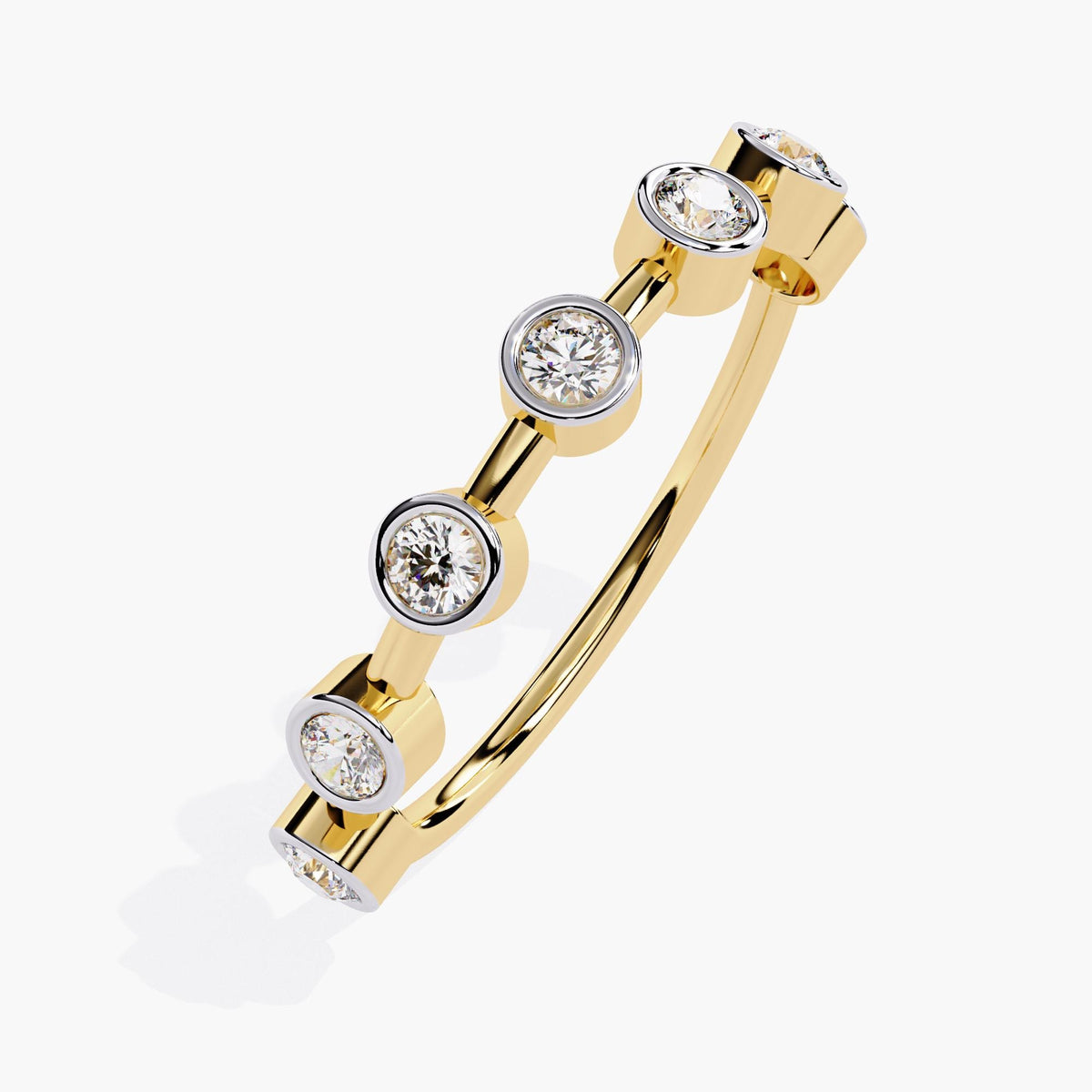 A yellow gold stacking ring with round diamonds set in polished bezel settings. The diamonds are spaced evenly along the band, creating a simple and modern look. The sleek, clean design makes it easy to stack with other rings or wear on its own, adding a timeless touch to your jewelry collection.