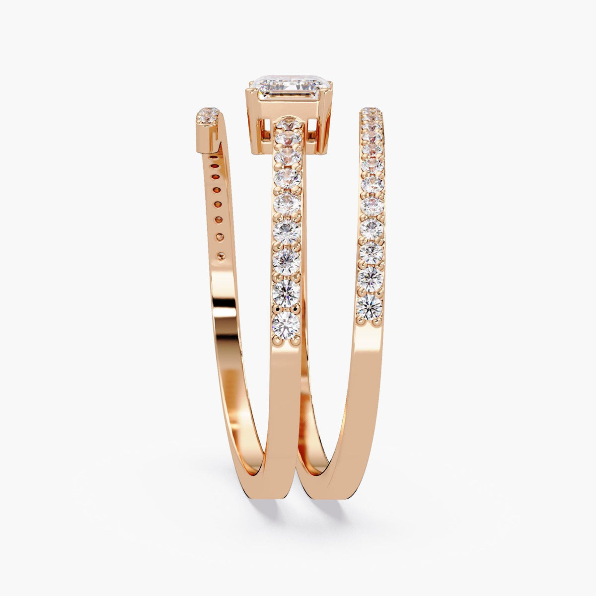 A 14K rose gold wrap ring with a center emerald cut diamond and three rows of small round diamonds in a bypass setting. The open design wraps around the finger with sparkling pavé-set diamonds on each band. Excellent ring to wear as statement jewelry and on pointer finger