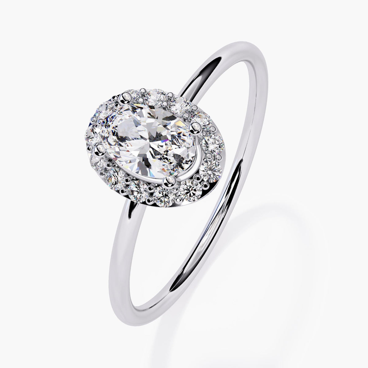 14k white gold halo engagement ring showcasing a 0.35 ct oval lab diamond at the center, surrounded by a frame of smaller round diamonds. The slim polished band and prong setting add a timeless, romantic feel.