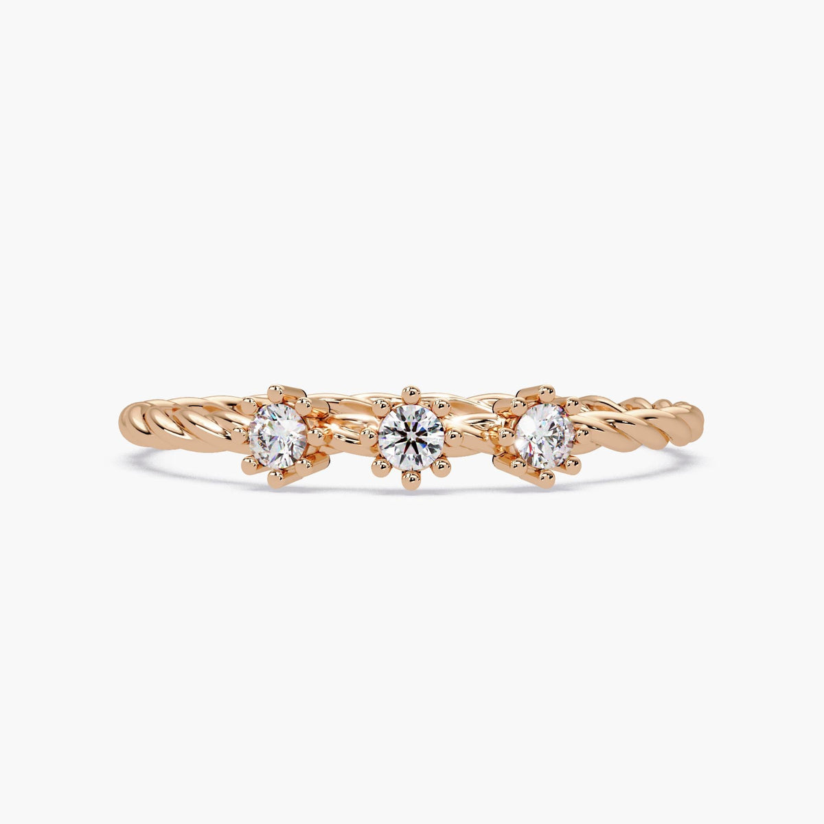 Front view of a 14k rose gold twisted band ring with three small round natural diamonds in six-prong floral settings.