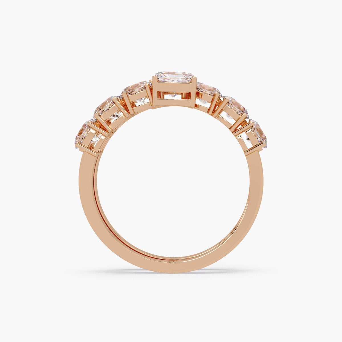 a spiral wrap ring in rose gold featuring two emerald cut diamonds at each open end, with two rows of oval diamonds set in shared prongs along a curved bypass band.