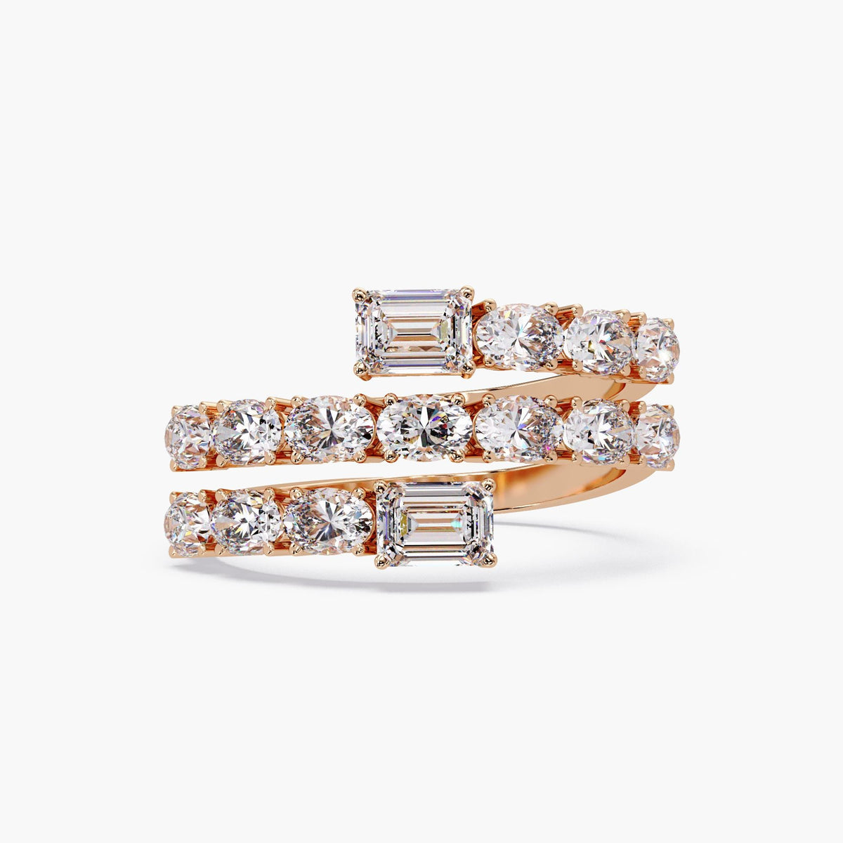 a spiral wrap ring in rose gold featuring two emerald cut diamonds at each open end, with two rows of oval diamonds set in shared prongs along a curved bypass band.