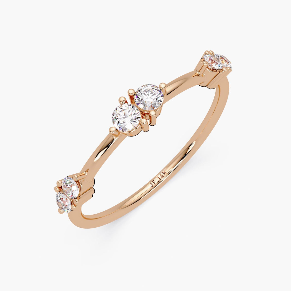 14K rose gold stacking ring featuring six natural round diamonds arranged in three prong-set pairs. Each stone is precisely spaced along a high-polish, tapered 1.3mm band. The soft blush tone of the rose gold contrasts elegantly with the sparkle of the diamonds, while the inside of the shank is engraved with "JF 14K" to indicate authenticity and gold purity. A delicate and feminine piece ideal for layering, gifting, or everyday wear.