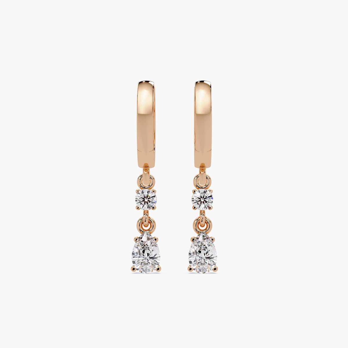 14K rose gold huggie earrings with dangling lab-grown diamonds in round and pear shapes. A lightweight, elegant design for everyday wear, date nights, or bridal gifting.