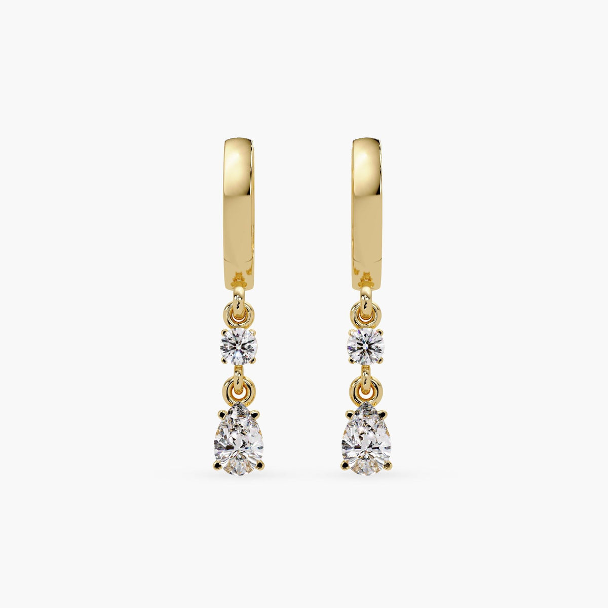 14K yellow gold huggie earrings featuring lab-grown diamonds in round and pear shapes. Each earring has a 3mm round diamond and a 6x4mm pear-shaped diamond set in a prong setting, hanging from a high-polish hinged hoop