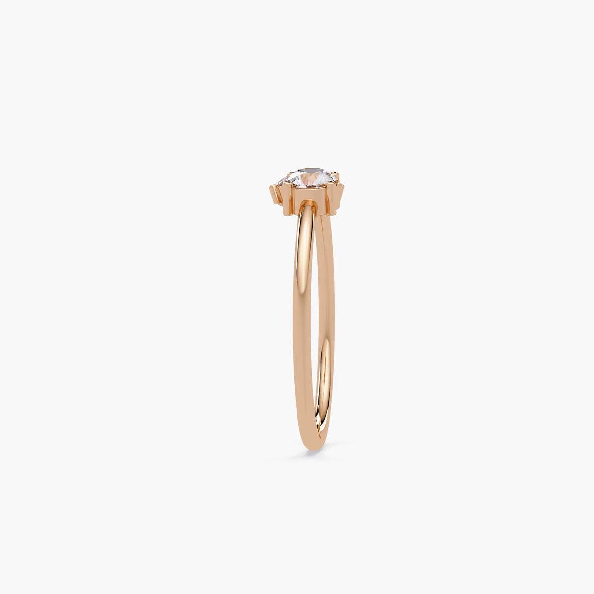 Side view of 14k rose gold three-stone lab diamond ring with slim polished band and elevated prong setting, showing diamond height and structure