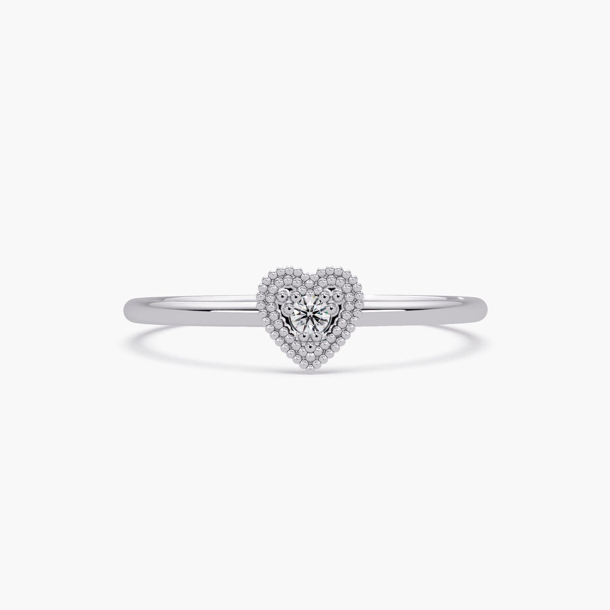 This is a dainty 14K white gold ring featuring a small beaded heart with a sparkling diamond in the center.