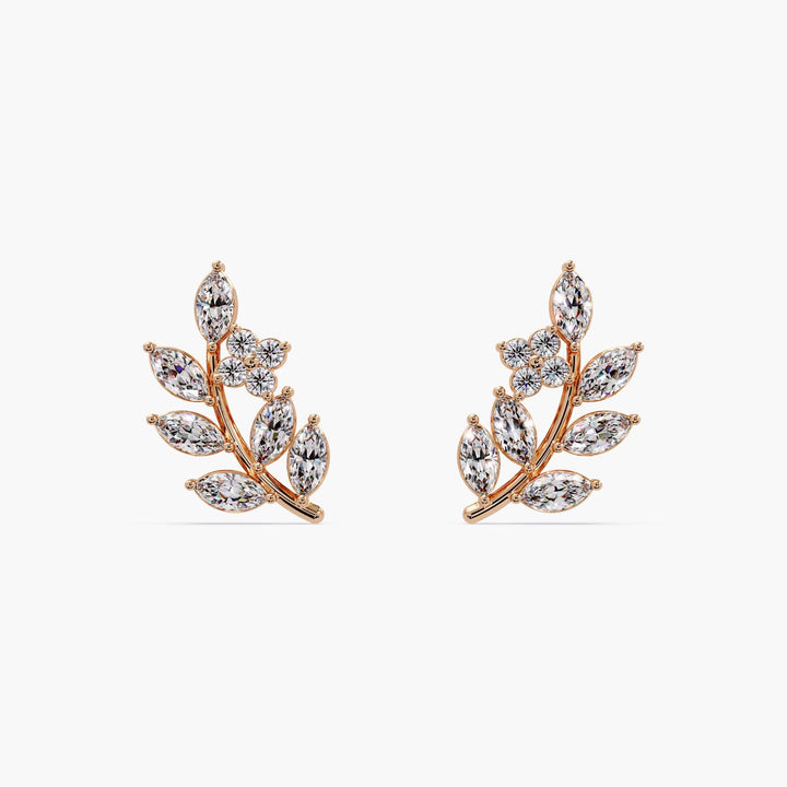 Pair of 14k rose gold leaf earrings displayed on a white background highlighting the elegant branch shape.