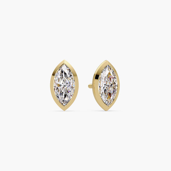 A pair of marquise cut lab grown diamond stud earrings set in 14k yellow gold bezel settings. The diamonds have pointed tips and a brilliant elongated shape. These minimalist earrings are secured with pushback posts, perfect for everyday wear, weddings, or gifting.