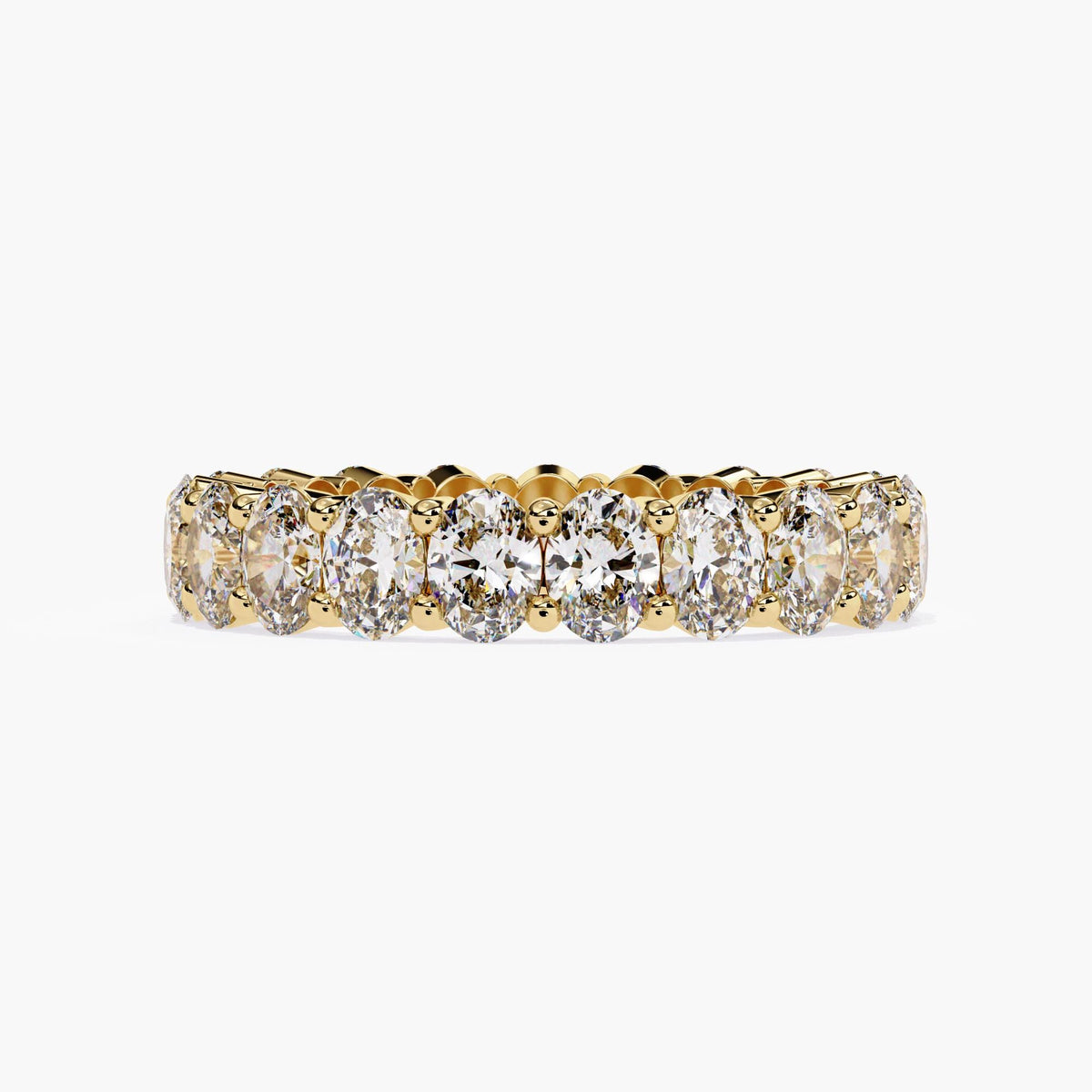 A gold band ring with a row of oval shaped diamonds set in a pave setting.